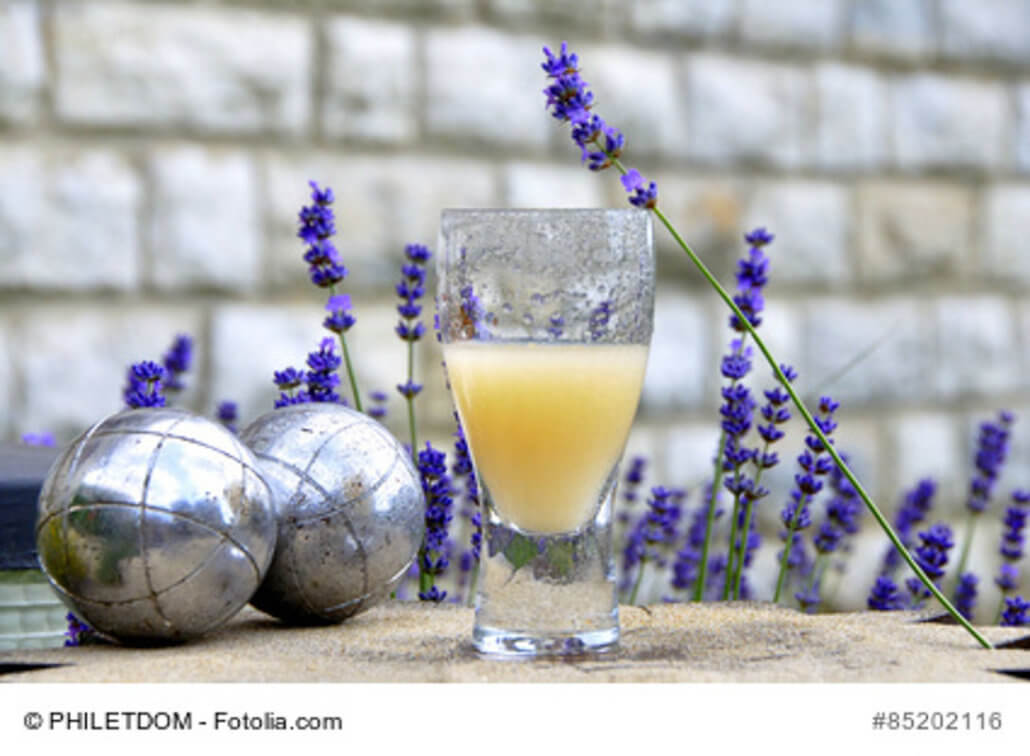 zeigt ein Glas Pastis und Lavendel